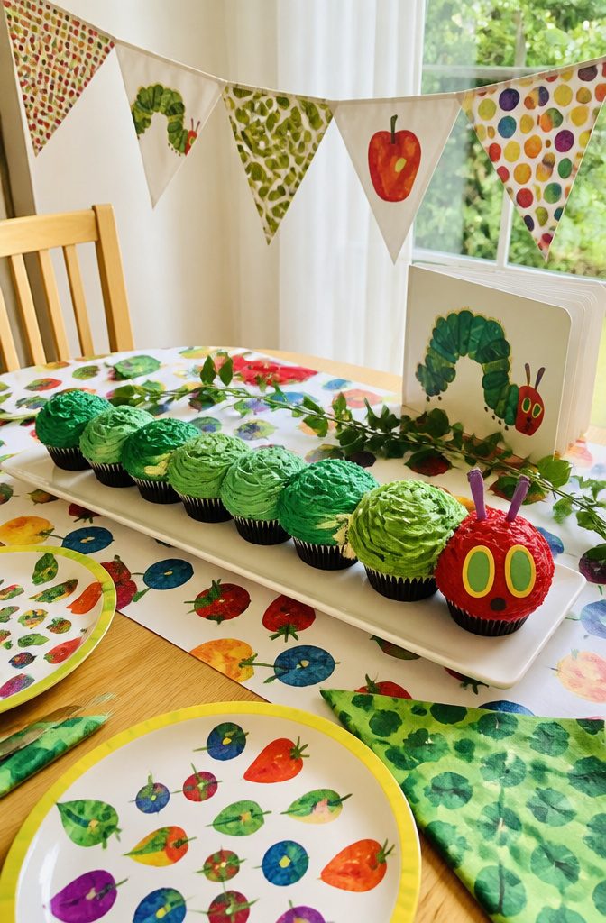 Cupcakes arranged in a line to resemble the Very Hungry Caterpillar.